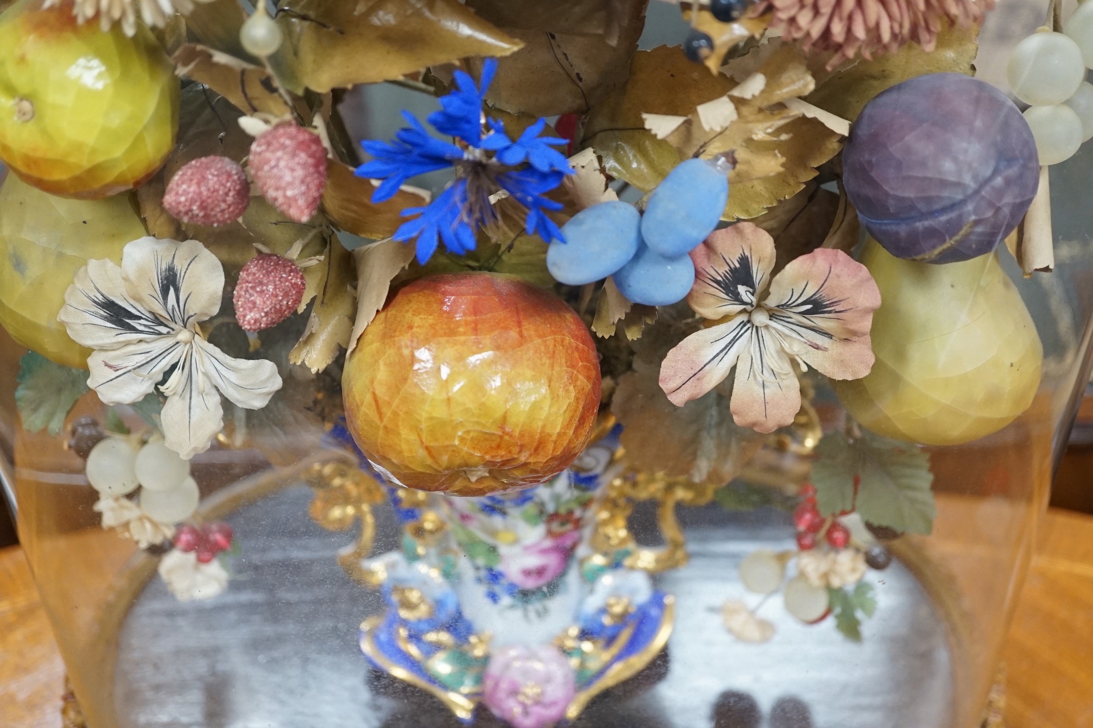 A Victorian painted mache fruit arrangement under a glass dome, 58cms high